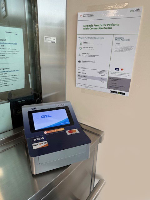 
			the hospital’s credit card deposit terminal located in the main lobby beside a metal and glass reception window.
