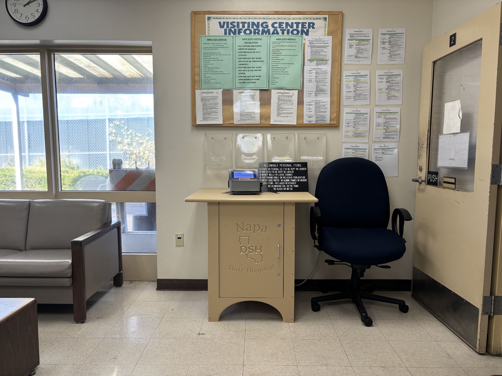 
			An image of one of the hospitals two credit card deposit terminals consisting of
a card machine mounted on a tan cabinet engraved with the hospital's logo, located in
the Secure Treatment Area Visitor Center beside a black office chair with a bulletin
board of visitor information on the wall behind it.